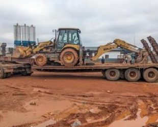 Tractopelles et porte-char sur la base